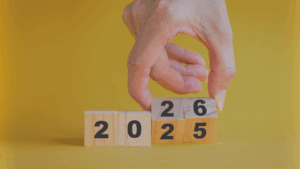 A hand flipping wooden number blocks to change 2025 into 2026, symbolizing a new year.